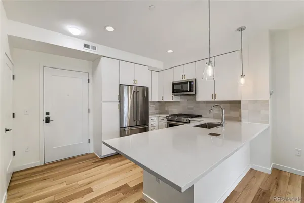 a kitchen with stainless steel appliances a refrigerator sink and microwave