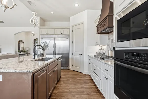a kitchen with stainless steel appliances granite countertop a sink stove and refrigerator