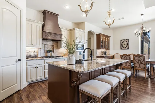 a kitchen with a table chairs sink and cabinets