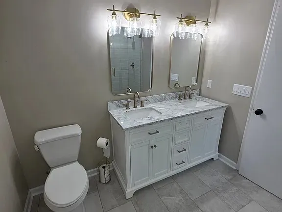 a bathroom with a toilet a sink and mirror