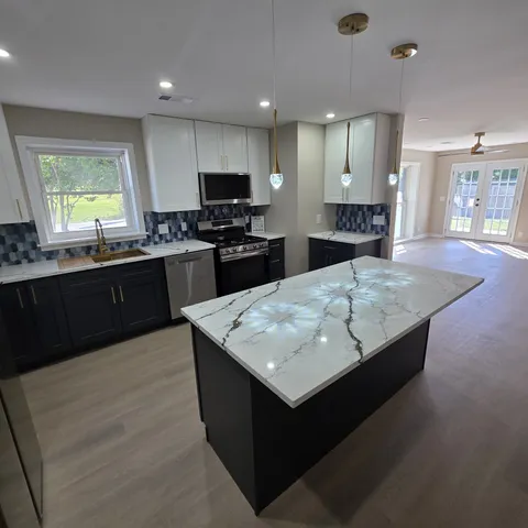 a kitchen with stainless steel appliances granite countertop a sink wooden cabinets and a granite counter tops