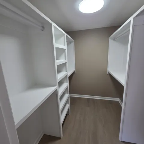 a view of walk in closet with empty racks