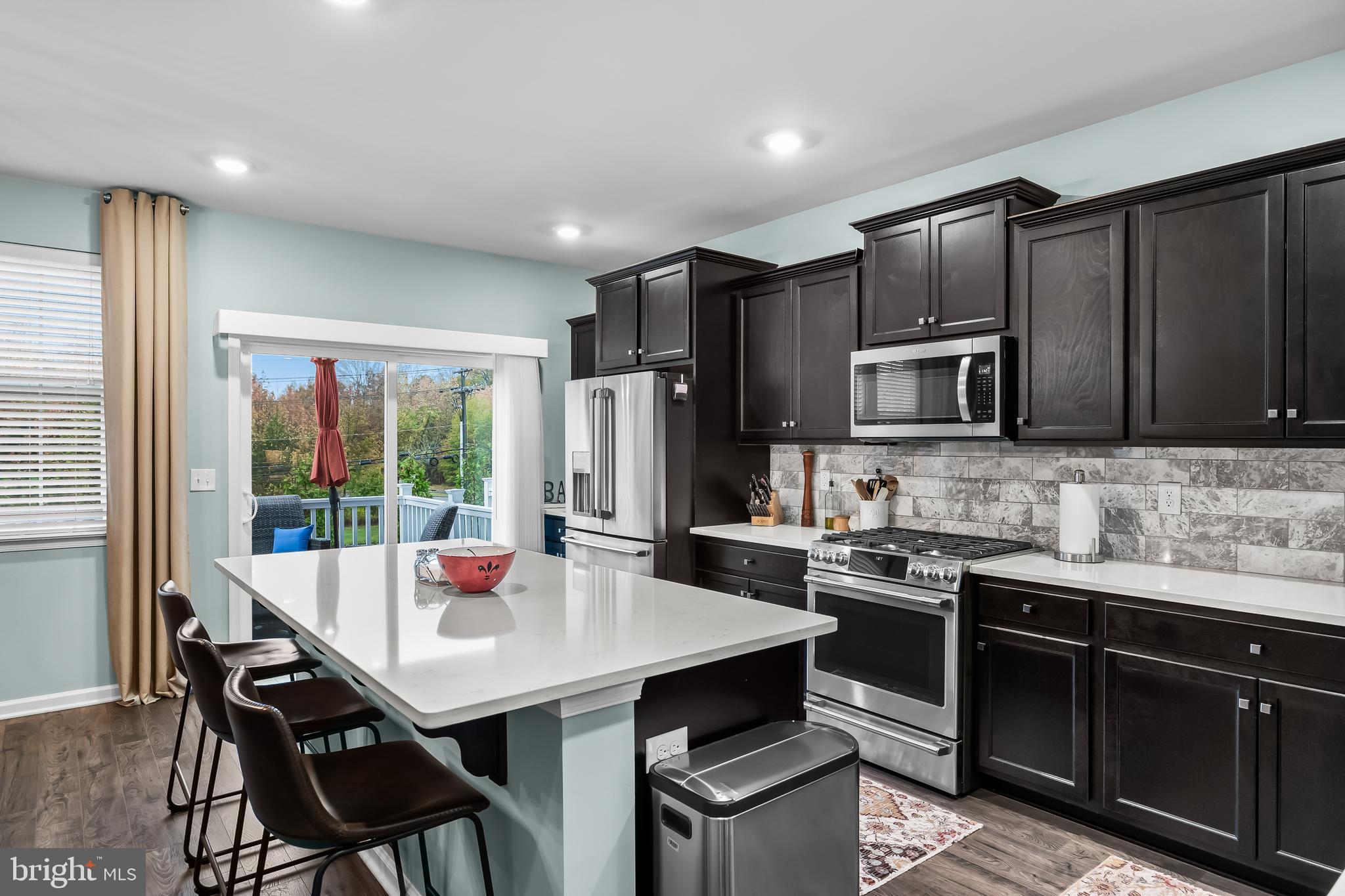 10 Naples Lane Mount Laurel, NJ 08054 - Photo 12 of 27 a kitchen with a stove a sink a microwave a dining table and chairs