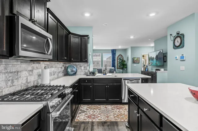 a kitchen with kitchen island a refrigerator stove and microwave