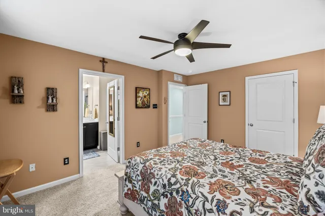 a bed sitting in a bedroom next to a window and a chandelier