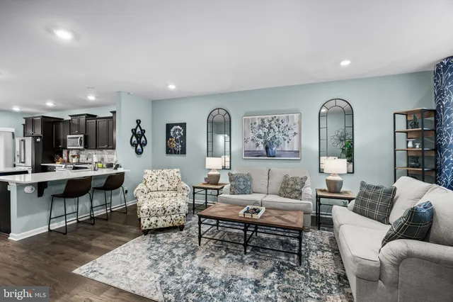 a living room with furniture rug and kitchen view