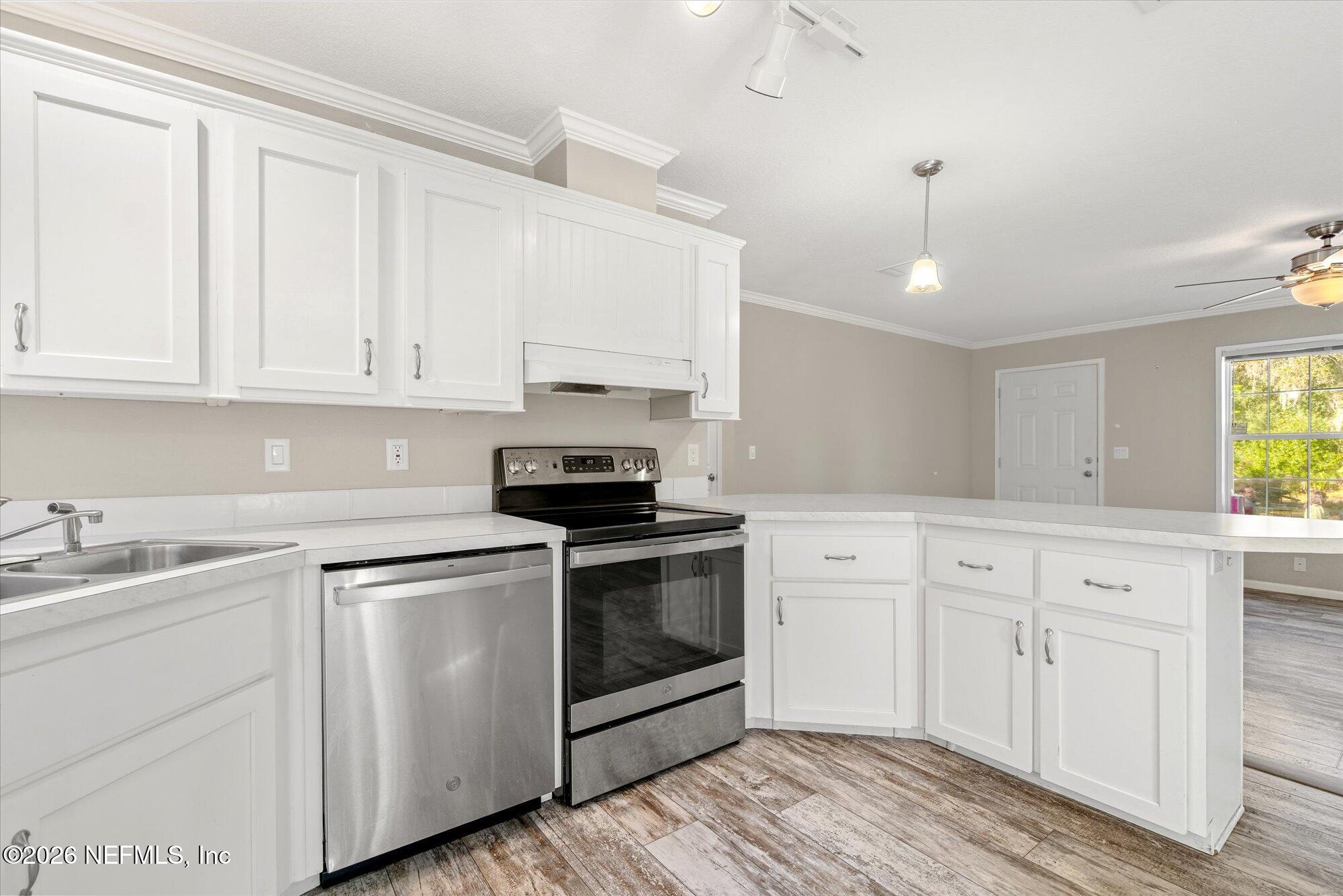 130 Sisco Road Pomona Park, FL 32181 - Photo 12 of 43 a kitchen with granite countertop white cabinets and white appliances
