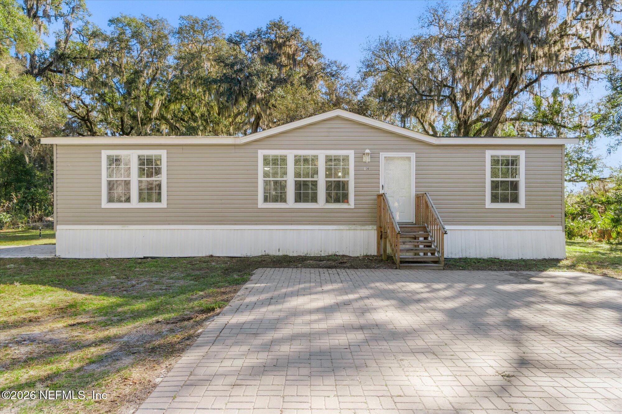 130 Sisco Road Pomona Park, FL 32181 - Photo 2 of 43 a front view of a house with a garden