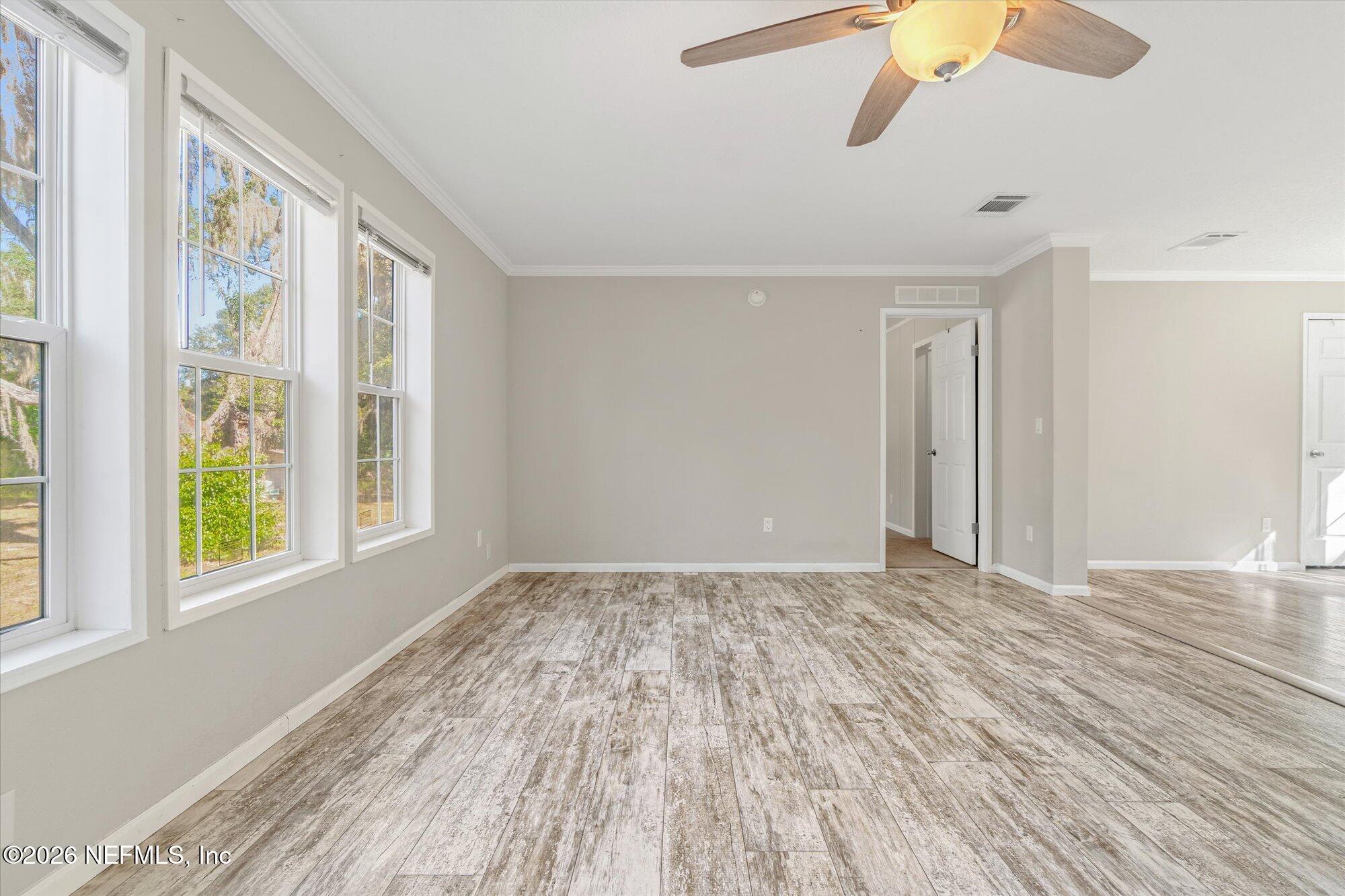 130 Sisco Road Pomona Park, FL 32181 - Photo 8 of 43 a view of an empty room with wooden floor and a window
