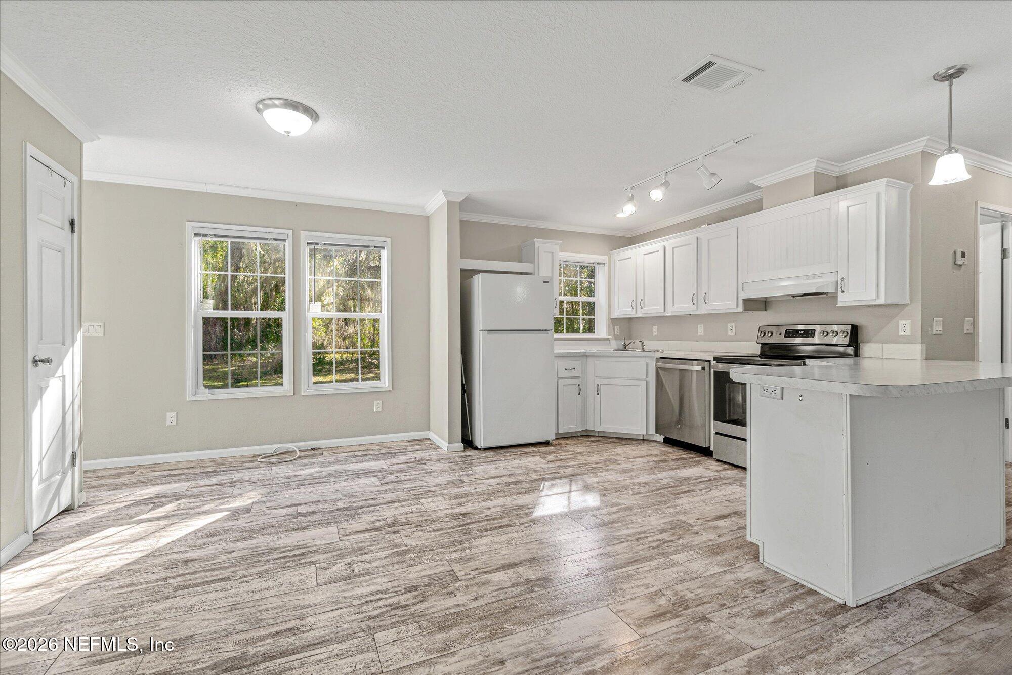 130 Sisco Road Pomona Park, FL 32181 - Photo 9 of 43 a kitchen with a refrigerator a stove top oven a sink and cabinets