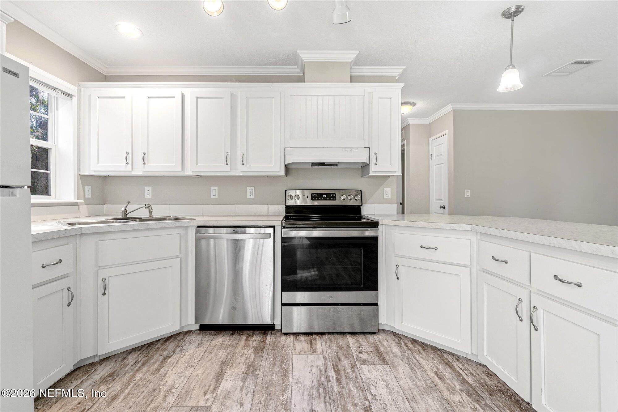 130 Sisco Road Pomona Park, FL 32181 - Photo 10 of 43 a kitchen with granite countertop white cabinets and white appliances