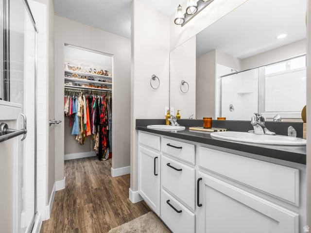 7 Sterling Loop Vineyard, UT 84059 - Photo 23 of 43 Double vanity with undermount sinks, dark countertop, and white cabinetry featuring matte black hardware