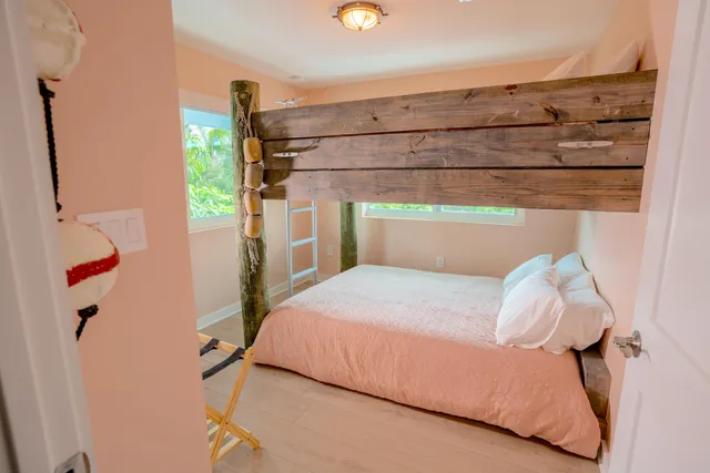 a bed sitting in a bedroom next to a window
