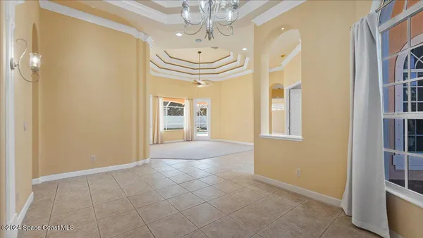 a view of a livingroom with a chandelier fan and windows