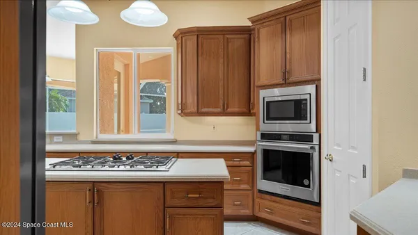 a kitchen with stainless steel appliances granite countertop a refrigerator a sink and a stove