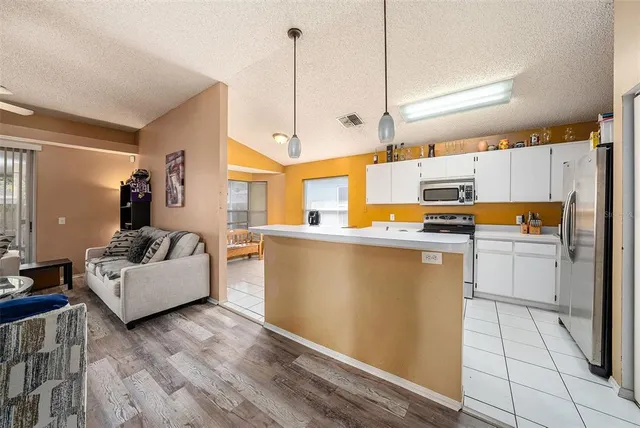 a kitchen with stainless steel appliances granite countertop a refrigerator a stove and a wooden floors