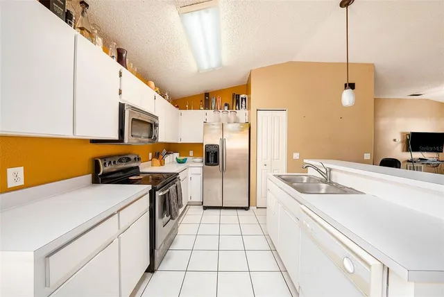 a kitchen with a sink a stove a refrigerator and cabinets