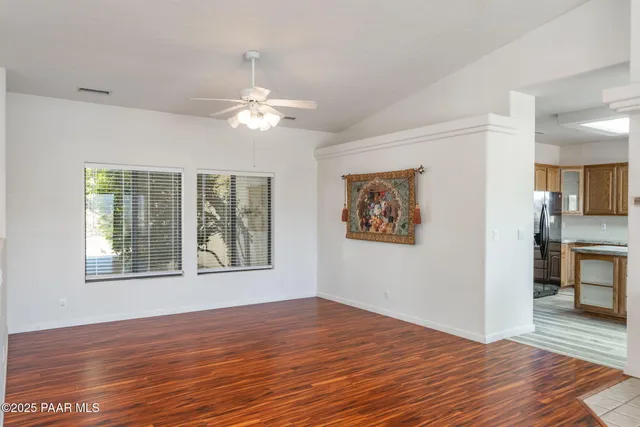 a large kitchen with a stove a sink dishwasher a refrigerator and wooden cabinets with wooden floor