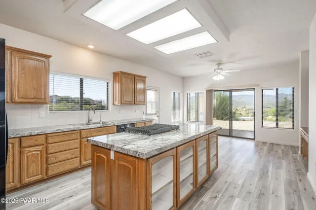 a view of a hallway with wooden floor and a bathroom