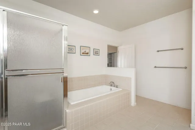 a view of an empty room with window a ceiling fan and wooden floor