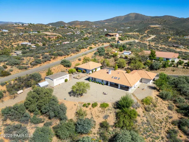 a view of empty room with wooden floor and kitchen