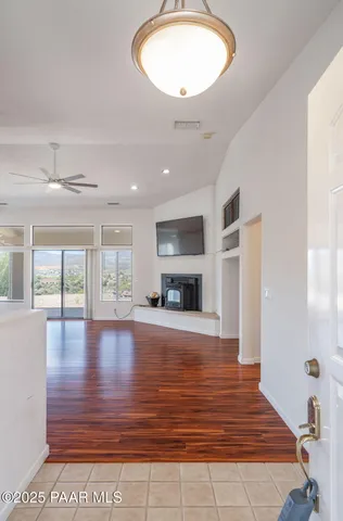 a view of an empty room with wooden floor and a fireplace