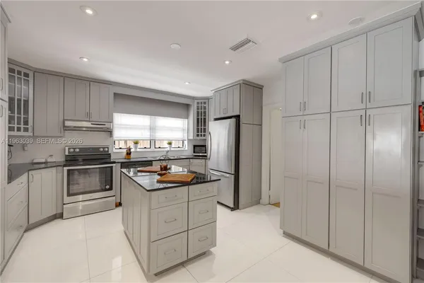a kitchen with stainless steel appliances granite countertop white cabinets and refrigerator