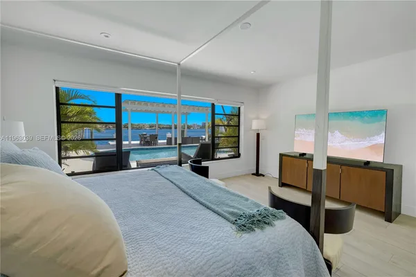 a large bedroom with a large bed and large windows