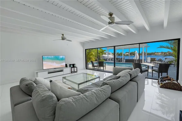 a living room with furniture pool table and a large window