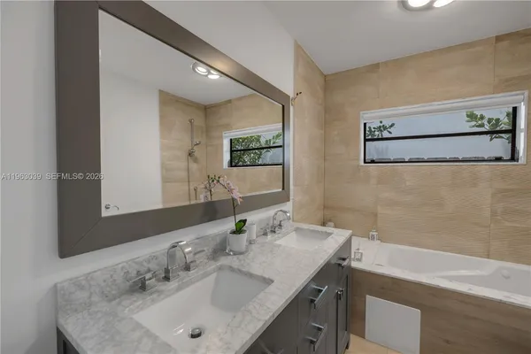 a bathroom with a granite countertop sink and a mirror