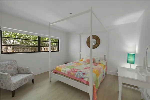 a bedroom with a bed a couch and a window