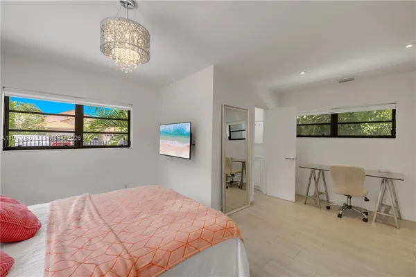 a bedroom with a bed and a chandelier