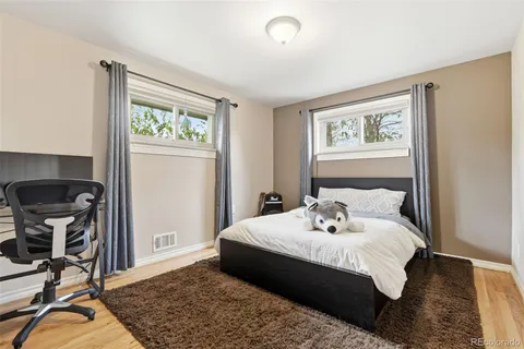 a bedroom with a bed and wooden floor