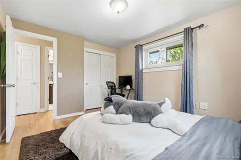 a bedroom with a bed and wooden floor
