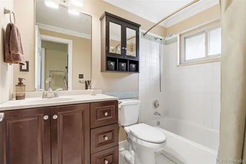 a bathroom with a granite countertop toilet sink and mirror