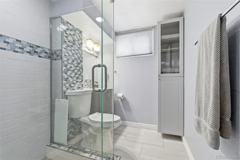 a bathroom with a toilet and a shower