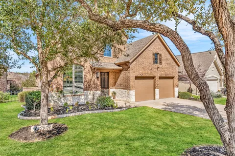 a front view of a house with a yard and trees