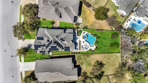 an aerial view of a house with a yard and a large tree