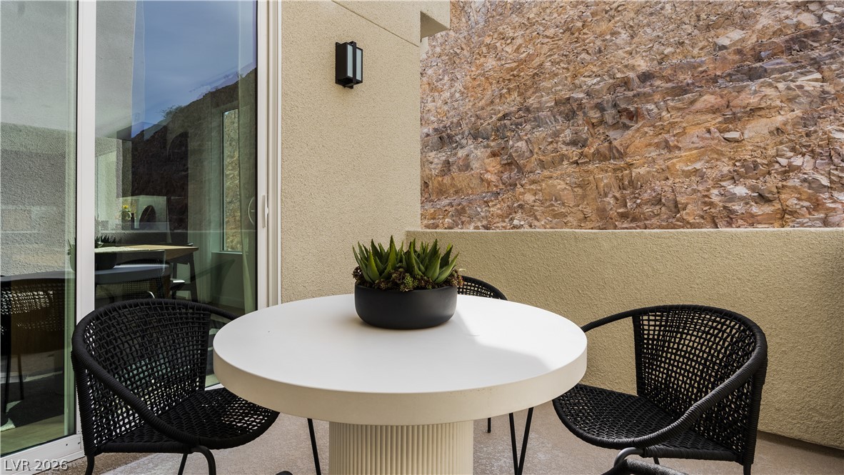 11115 Socrates Ridge Street Las Vegas, NV 89141 - Photo 11 of 21 Sliding glass doors open onto a private balcony set against a dramatic rock face.