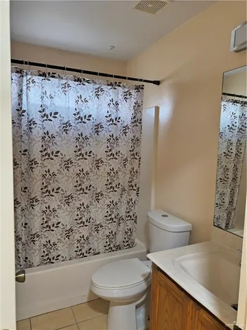 a bathroom with a toilet and a shower curtain