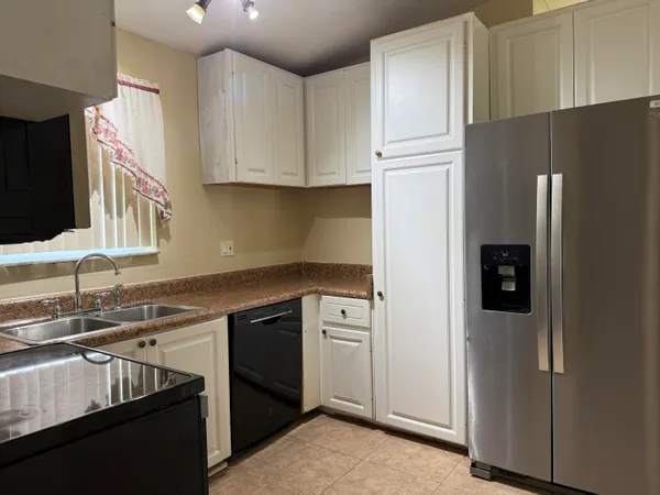 a kitchen with stainless steel appliances granite countertop a refrigerator and a sink