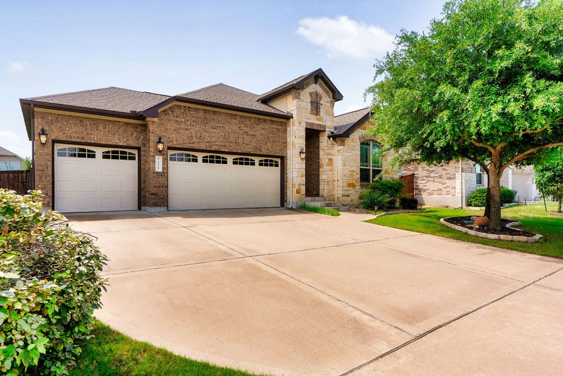 a front view of a house with a garden and garage