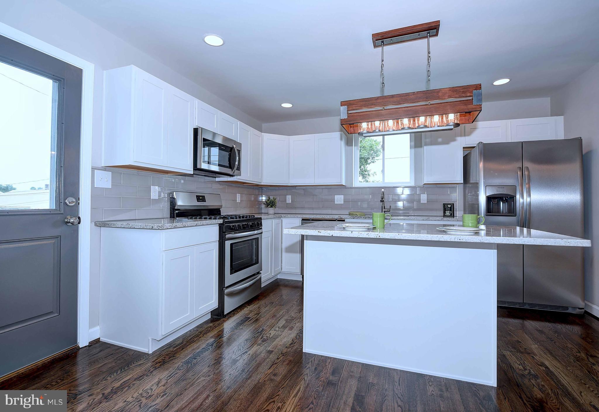 1213 Ridgeshire Road Baltimore, MD 21222 - Photo 11 of 30 a kitchen with stainless steel appliances granite countertop a refrigerator a sink dishwasher a stove and white cabinets with wooden floor
