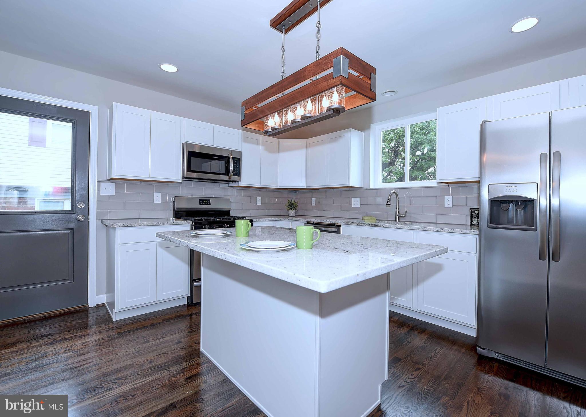 1213 Ridgeshire Road Baltimore, MD 21222 - Photo 13 of 30 a kitchen with stainless steel appliances a sink a stove a refrigerator cabinets and a window