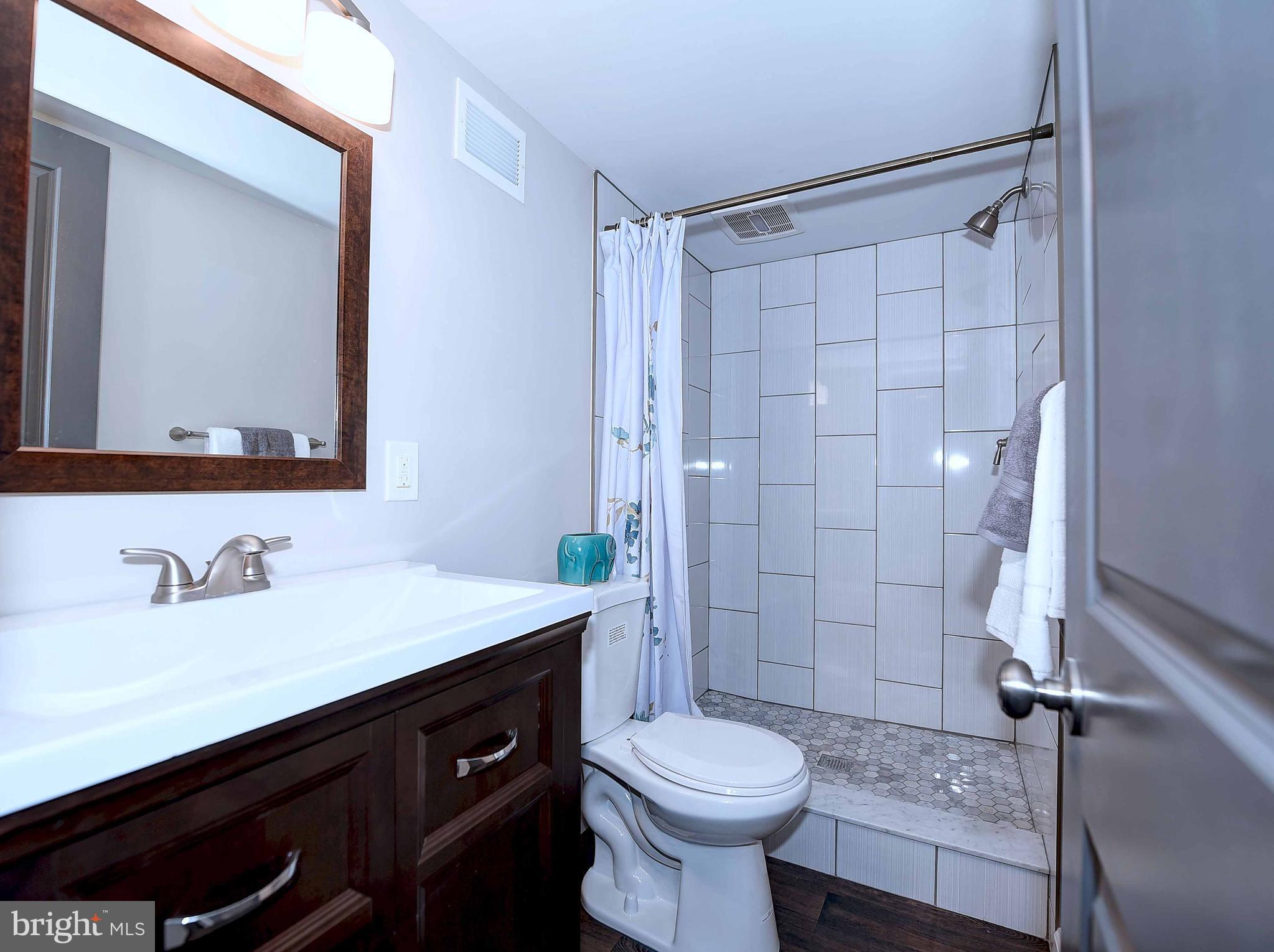1213 Ridgeshire Road Baltimore, MD 21222 - Photo 27 of 30 a bathroom with a sink a toilet and shower