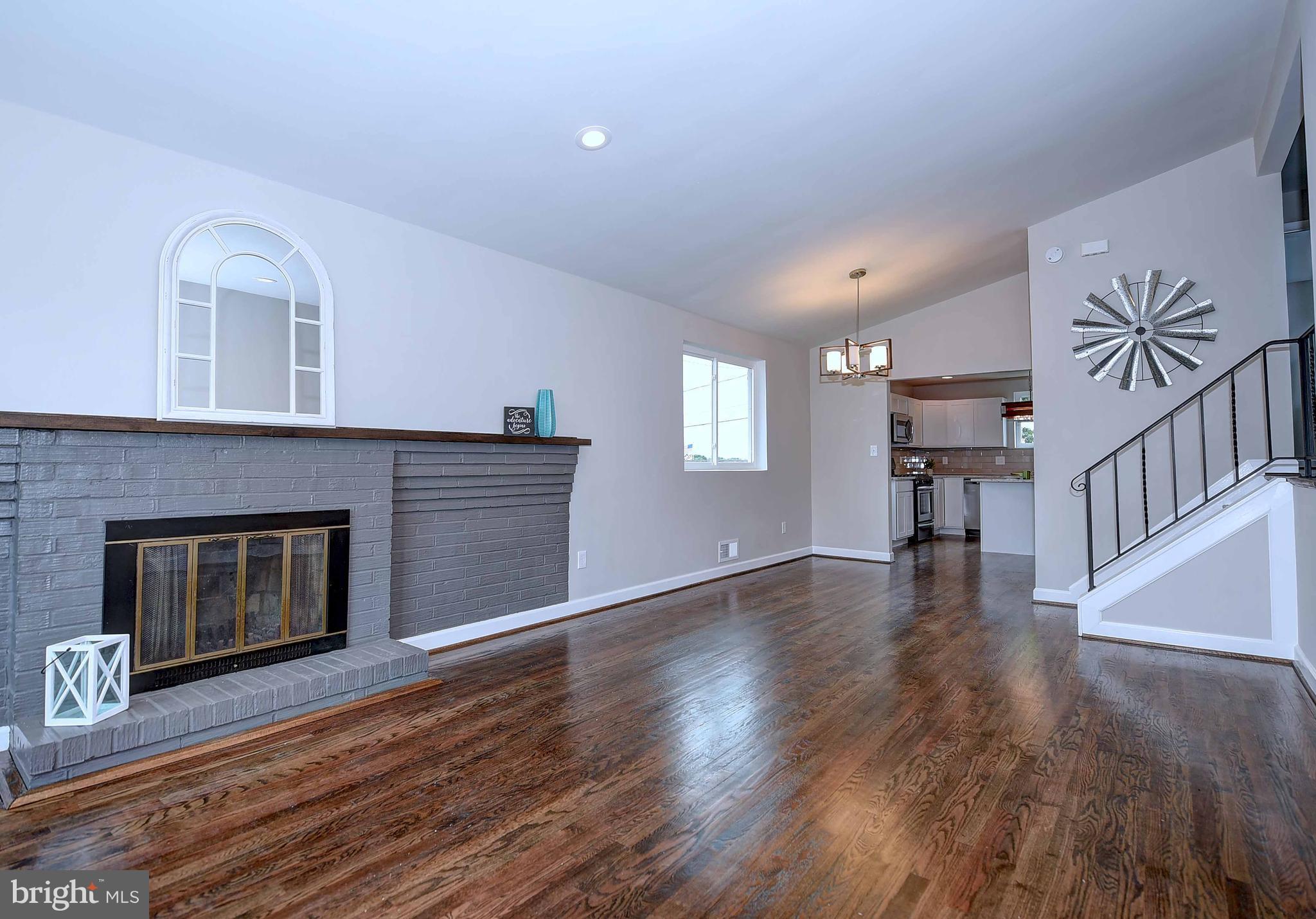 1213 Ridgeshire Road Baltimore, MD 21222 - Photo 5 of 30 a view of an empty room with wooden floor and a fireplace