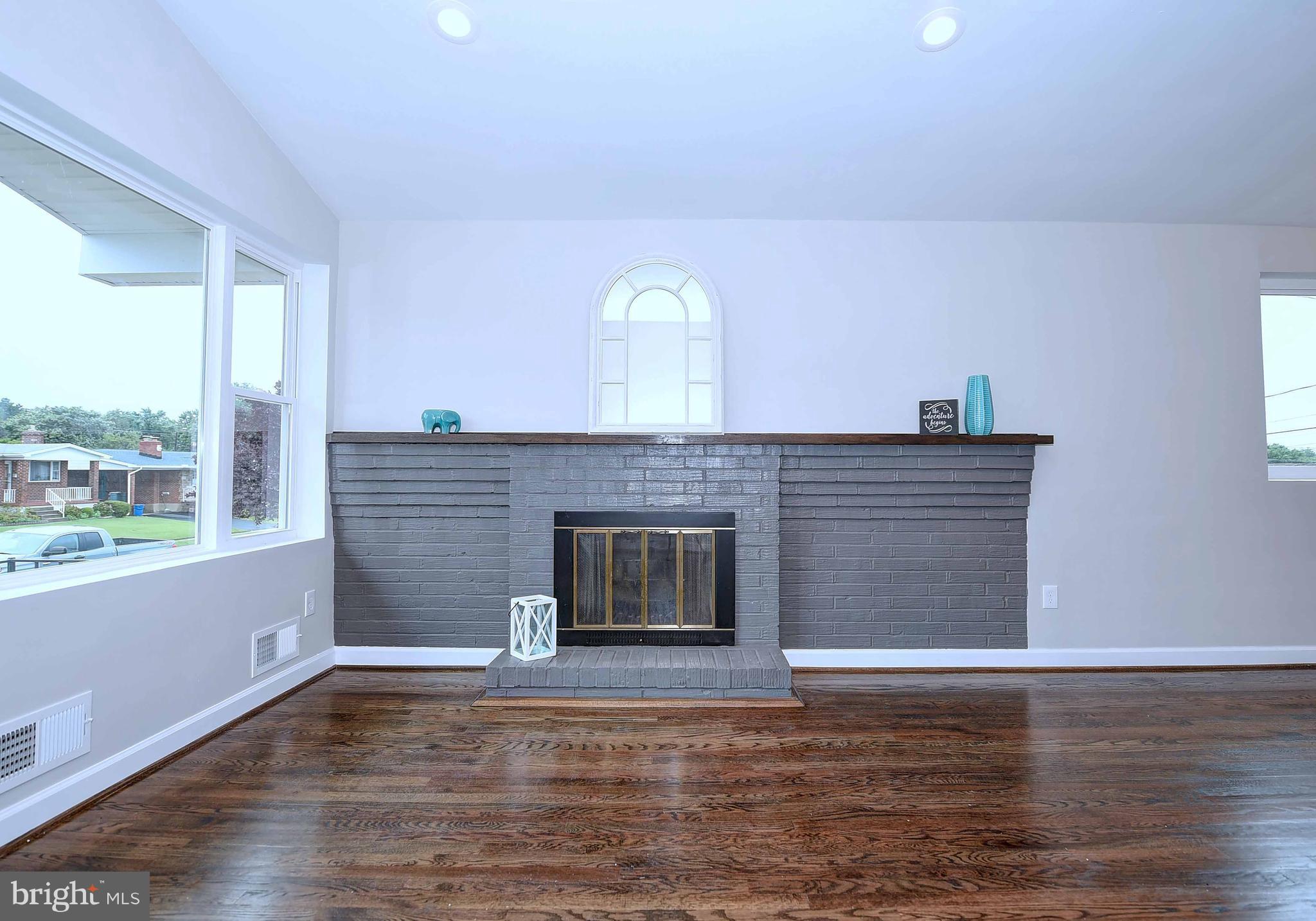 1213 Ridgeshire Road Baltimore, MD 21222 - Photo 6 of 30 a view of empty room with wooden floor and fireplace