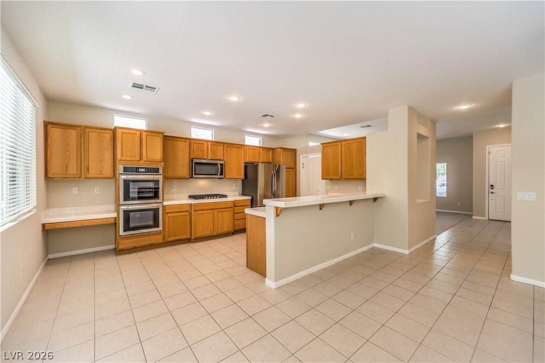 3713 Spring Shadow Road Las Vegas, NV 89129 - Photo 14 of 37 A well-appointed kitchen showcasing durable tile flooring and integrated cooking appliances.
