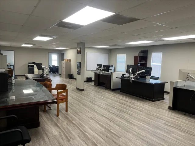 a living room with furniture a wooden floor and kitchen view