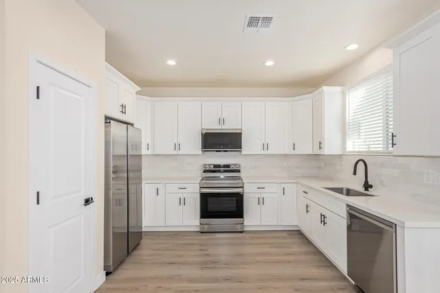 a kitchen with white cabinets and stainless steel appliances